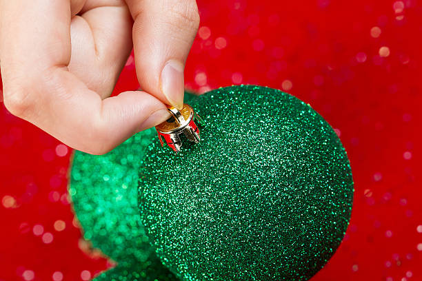 istock Picking up Green Christmas Ornament 186625724