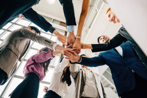 istock An under shot captures four diverse business colleagues in a unity circle stacking their hands. This symbolizes teamwork success and global cooperation in the corporate world. 1866264410