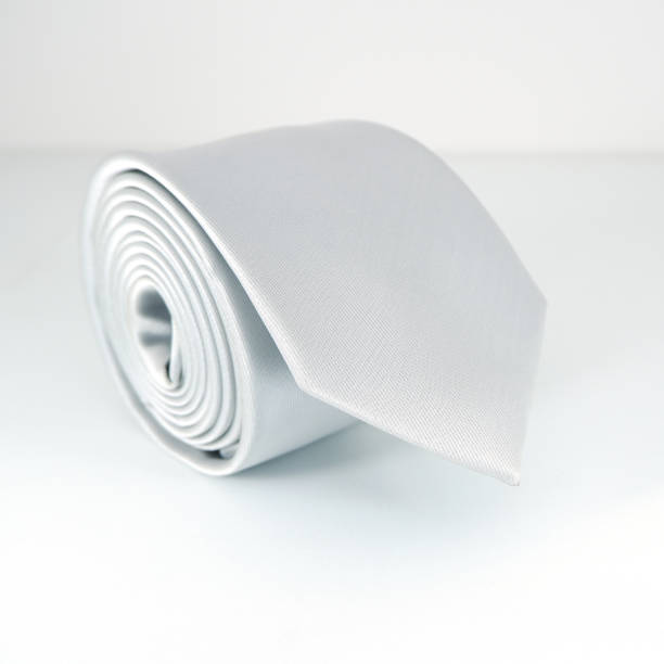 istock Plain fabric white necktie rolled on white background close-up view single object concept no people 1866309194