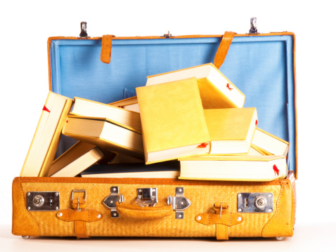 a travel suitcase full of books on a white background