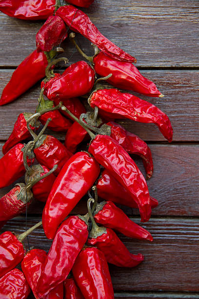 espelette peppers hanging en una puerta de madera - apo island fotografías e imágenes de stock