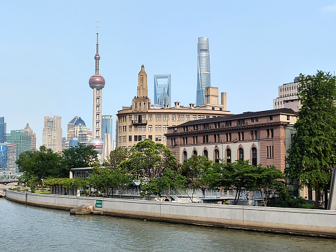View of the futuristic Lujiazui finance and trade zone skyline surrounding art deco buildings in The Puxi area by the Bund, Shanghai, China