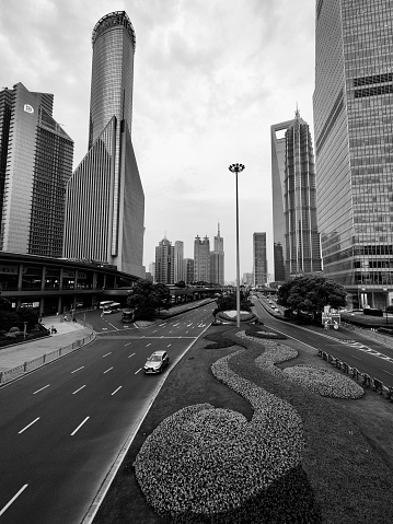 Traffic on Shiji boulevard under the tall skyscrapers in Lujiazui finance and trade zone, Shanghai, China