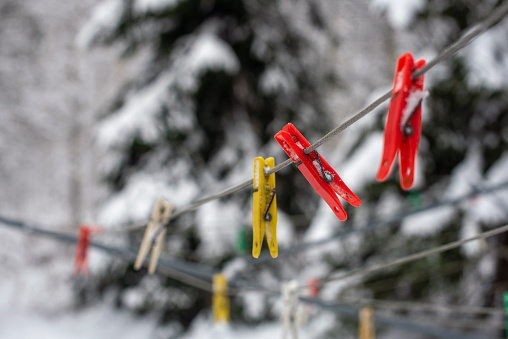 Colorful clothespins hanging on a string on a bright winter day