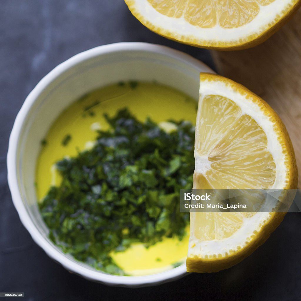 Fresh salad dressing of olive oil, lemon juice, herb parsley Fresh salad dressing of olive oil, lemon juice and herb parsley in white cup Appetizer Stock Photo