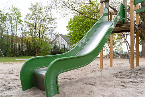 Green metal slide for children in the playground
