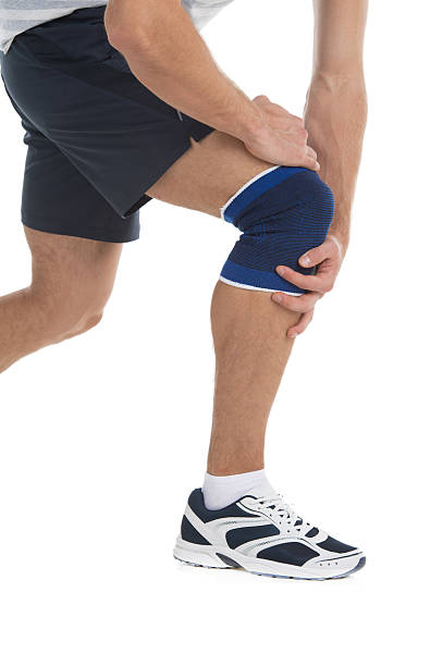 dolore al ginocchio - human knee physical injury bandage muscular build foto e immagini stock