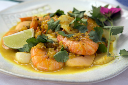Homemade Indian dish with jumbo shrimp and fresh flowers.