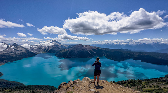 Young woman hiker looking at Garibaldi Lake from Panorama Ridge in summer in Squamish, BC, Canada