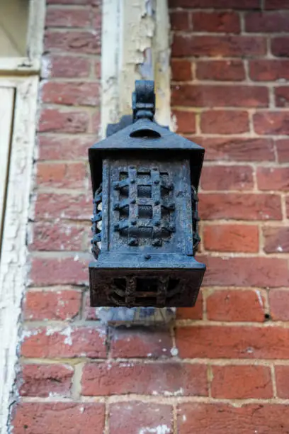 Old wrought iron light fixture on historic building exterior