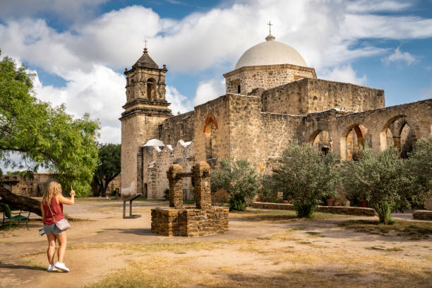 Female tourist photographing Mission San JosÃ©, built in 1720, known as the Queen of the Missions in the historical park, San Antonio, Texas, USA