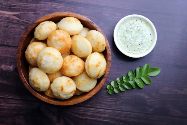 istock Paniyaram are savory balls made using fermented rice and urad dal batter along with tempered onion and spices. Also known as Paddu, Ponganalu, Kuli, bugga, and appe. served with coconut chutney 1866479038