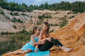 loving mother and her young daughter share a tender moment during a serene outdoor exercise session, showcasing family fitness amidst the natural beauty of a lakeside landscape