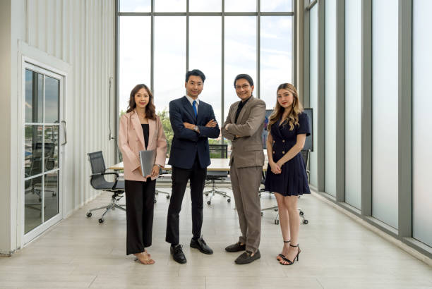 istock Four people stand together in a bright office with big windows on a sunny day. 1866528948