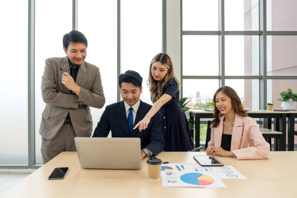 istock Business professionals collaborating with enthusiasm while examining data on a laptop in a contemporary office setting. 1866529973
