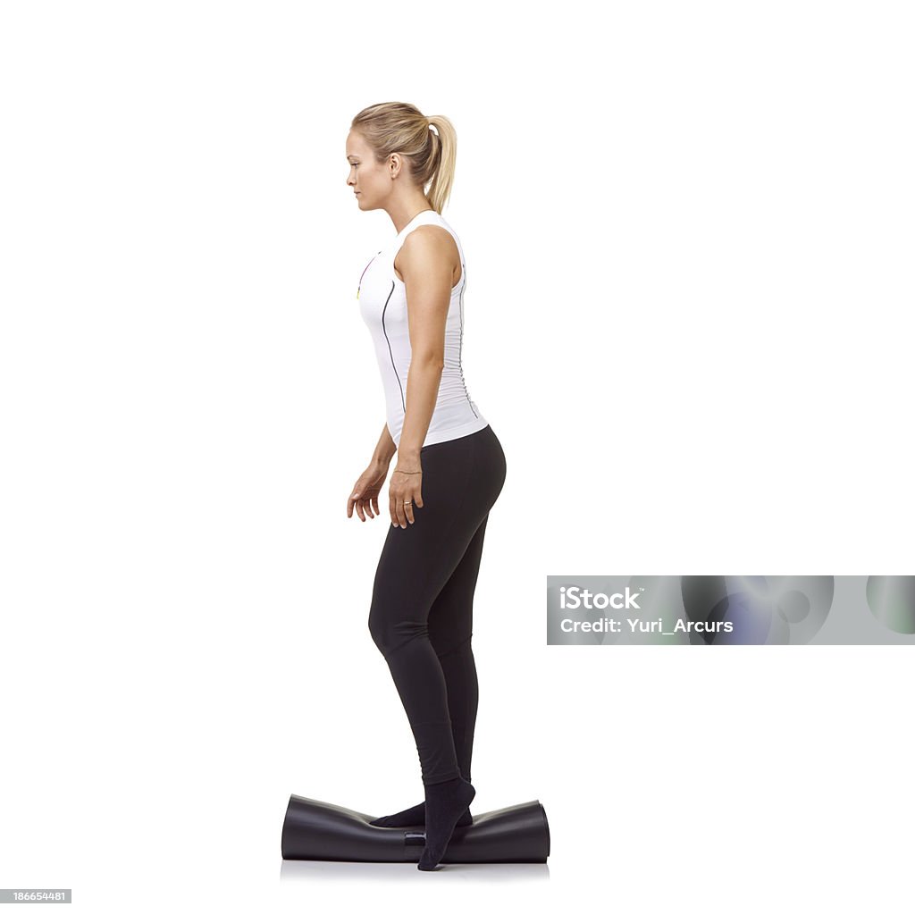 Balance and stamina A pretty young woman balancing on her rolled up exercise mat - isolated 20-29 Years Stock Photo