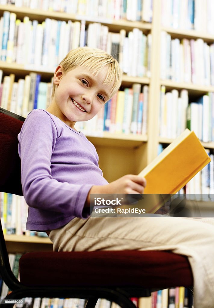 Я Люблю читать. Маленькая блондинка девочка в библиотеке smiles - Стоковые фото 6-7 лет роялти-фри