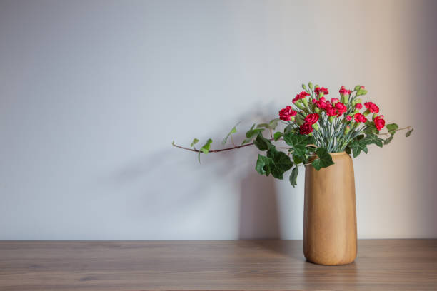 istock red carnations  in modern vases on background gray wall 1866577340