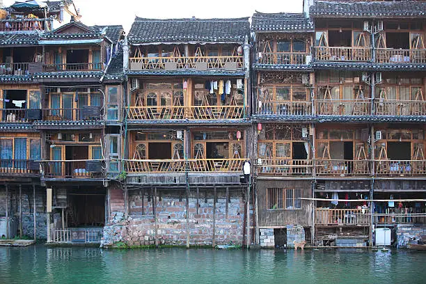 wooden house projecting over the water built beside tuojiang river in fenghuang ancient town,china