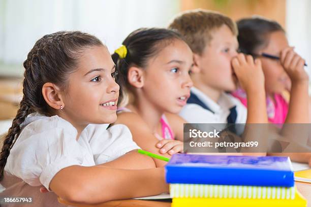 Foto de Quatro Diligentes Alunos A Estudar Em Sala De Aula e mais fotos de stock de Aluna - Aluna, Aluno de Primário, Amizade