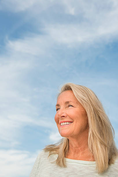 istock Thoughtful Woman Against Cloudy Sky 186658085