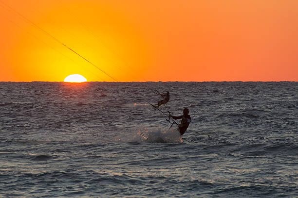 kitesurfing silhouette against the setting sun at sunset