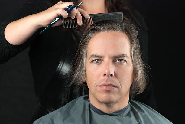 istock Man Getting Long Hair Combed In Preparation For Cut 186660152