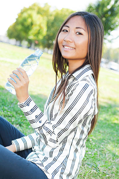 istock Asian girl drinking water in a park 186662030
