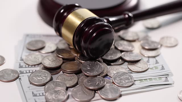Judge gavel with cash and coins on table slow motion 4k movie