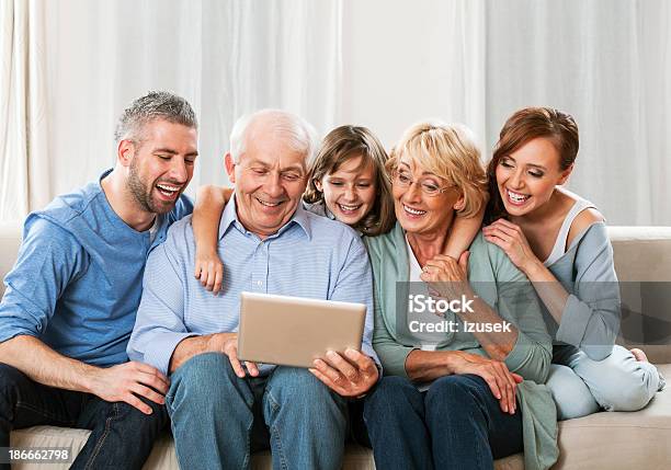 Family Using A Digial Tablet Together Stock Photo - Download Image Now - Crowded, Family, Active Seniors