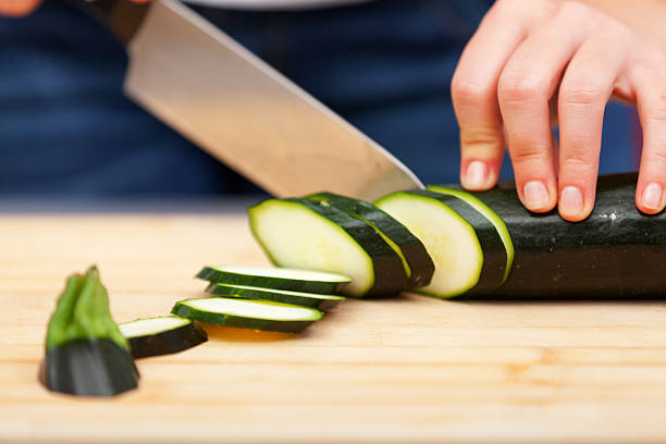 istock Young woman cutting zucchini 186663397