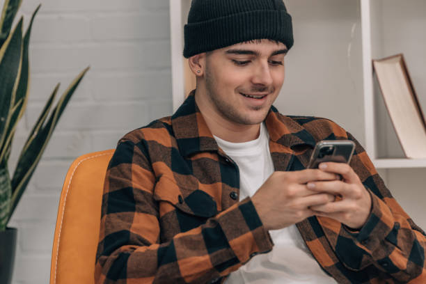 istock young man at home on the sofa looking at the mobile phone 1866635899