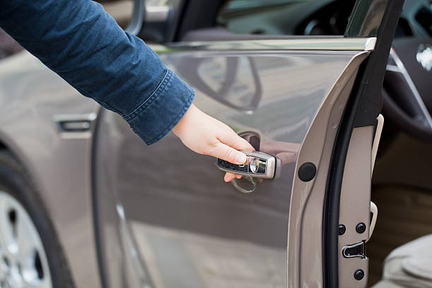 Hand opening the driver side door of vehicle stock photo