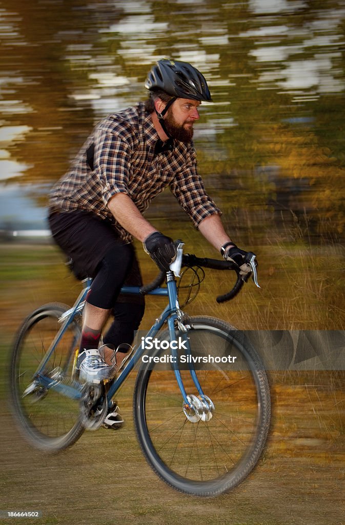 Uomo che cavalca sua cyclocross cyclette su un percorso. - Foto stock royalty-free di Adulto