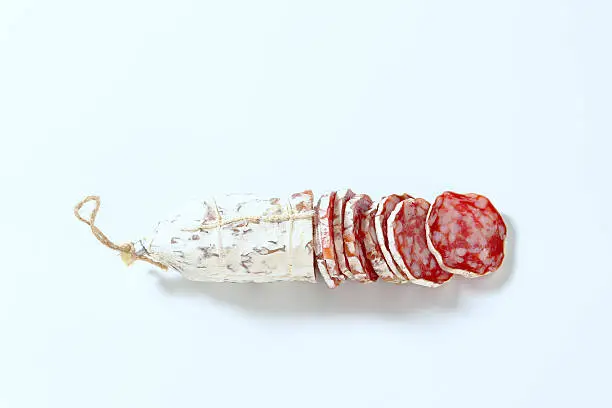 sliced french dried salami on white background