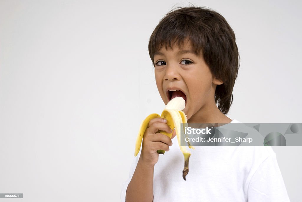 ヒスパニック男の子食事、バナナ - 1人のロイヤリティフリーストックフォト