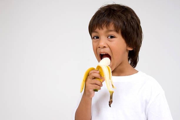 istock Hispanic boy eating a banana 186666711