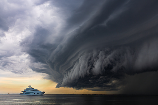 A massive storm moving in to land over the ocean forming into a \