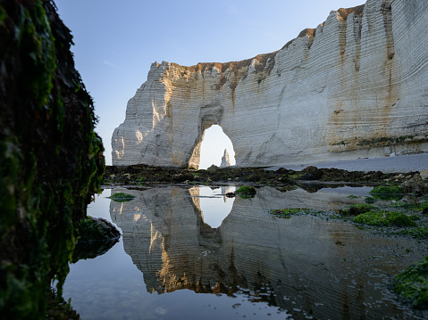 Chalk cliffs of Etretat (Normandy France) on a sunny day in summer, reflection in water