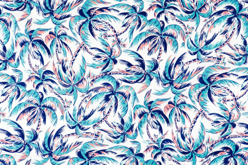 Vintage fabric background depicting blue palm trees on a white background from the era of 1962 to 1972. Similar to fabric used in Hawaiian shirts.