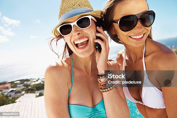 Foto de Duas Mulheres Sorridentes Em Trajes De Banho Com Telefone Celular e mais fotos de stock de Discussão