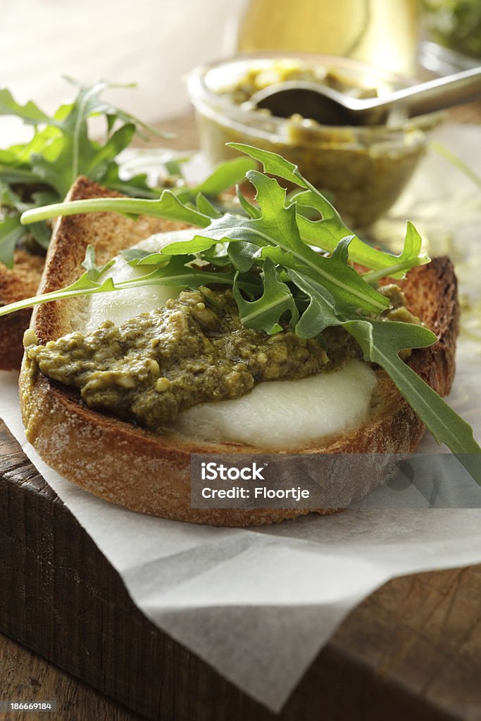 Italian imagens estáticas: Bruschetta com queijo mussarela, Pesto e Arigula - Foto de stock de Bruschetta royalty-free