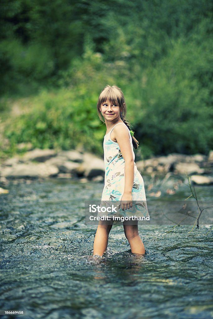 Piccola ragazza attraversando un fiume - Foto stock royalty-free di Acqua