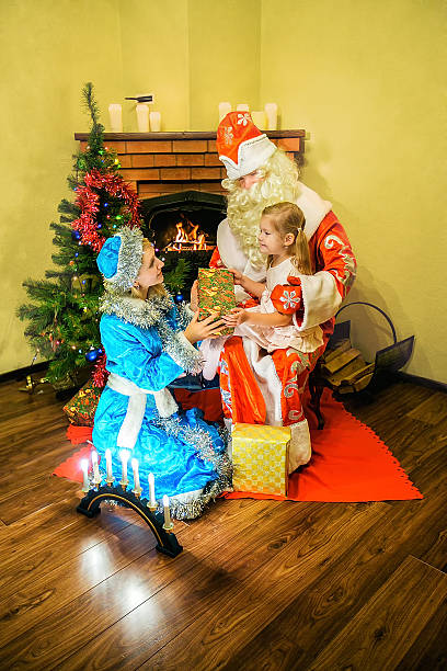 санта-клаус и снег maiden представлены подарок для девушек. - snow maiden стоковые фото и изображения