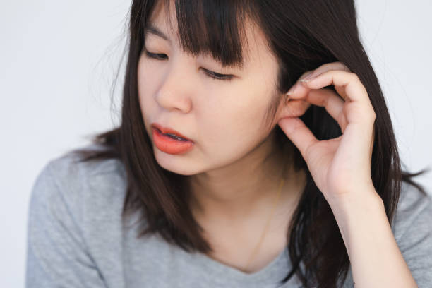 istock A woman has itching and irritation around her ears and inside her ears. 1866713196