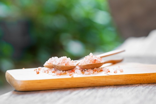 Himalayan salt or pink salt in a wooden spoon on the table.