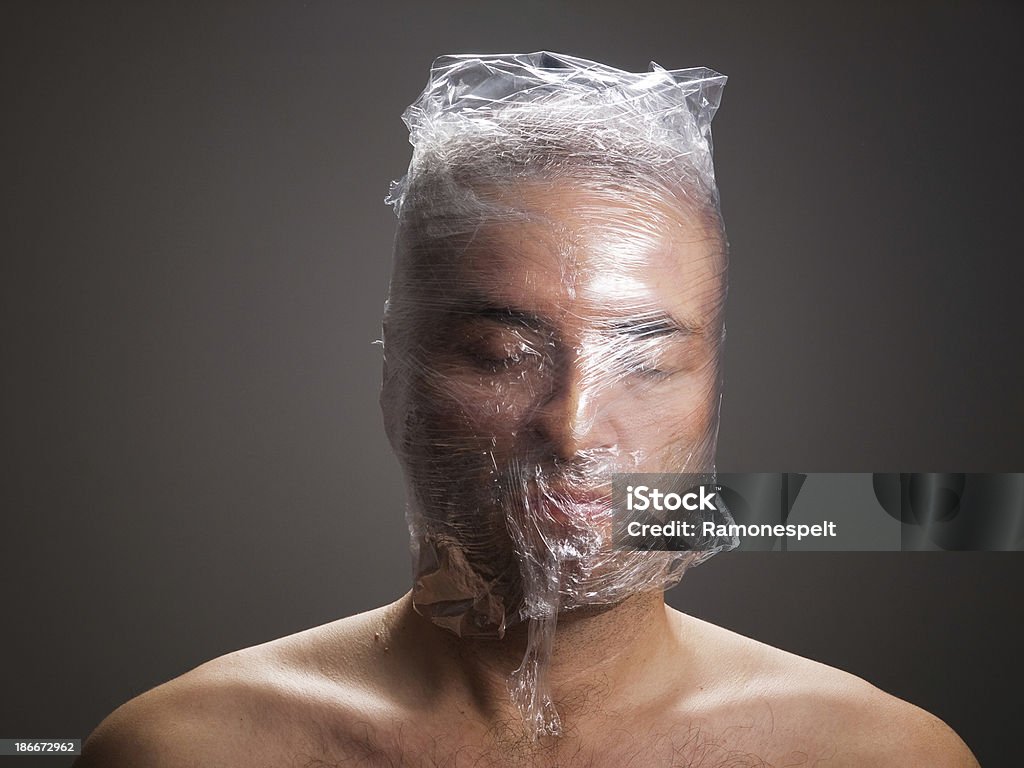 Człowiek duszący z tworzyw sztucznych na głowie - Zbiór zdjęć royalty-free (Ciemny)