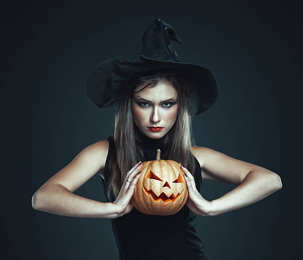 istock The serious girl is standing with pumpkin 186673272