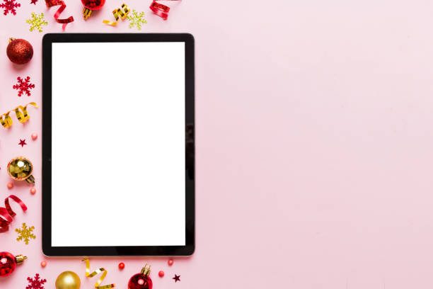 istock Christmas online shopping from home tablet pc with blank white display top view. Tablet with copy space on colored background with Christmas decorations balls,. Winter holidays sales background 1866732927