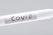 The inscription Covid on a plastic sample for testing in the laboratory